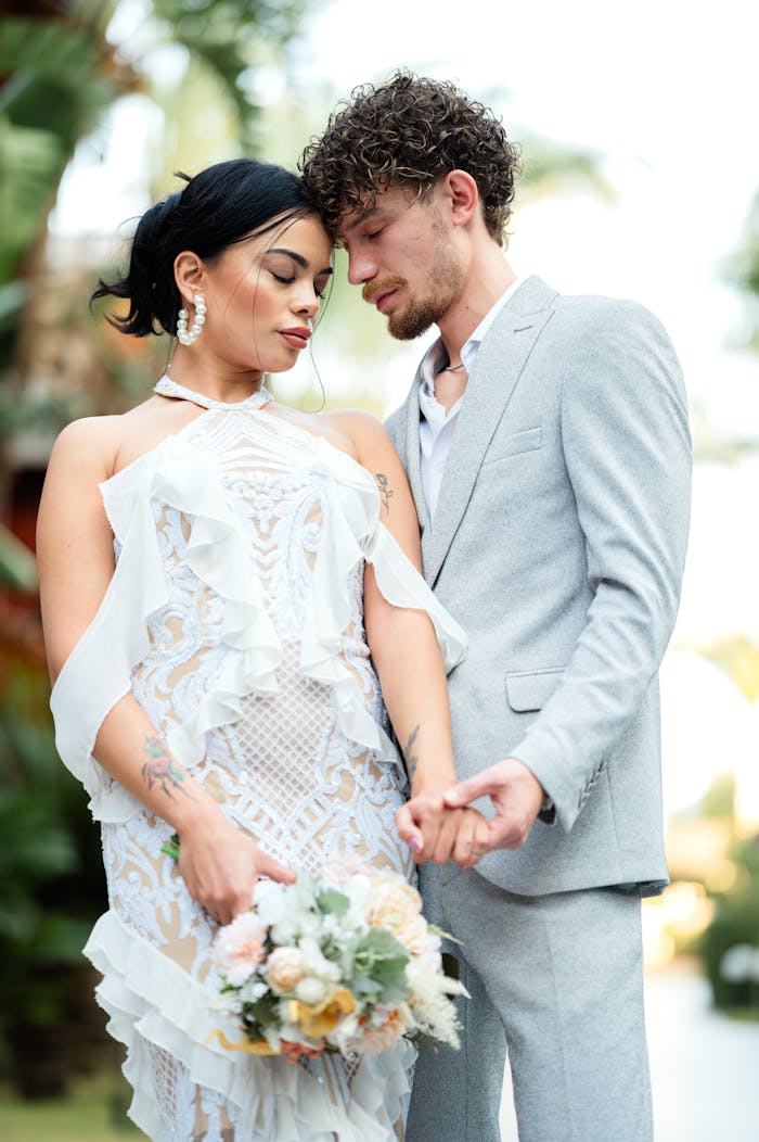 why-choose-us Romantic couple in stylish attire sharing a tender moment outdoors with a bouquet.